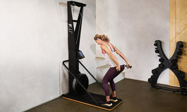 woman using a ski machine in a home gym