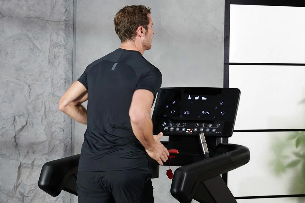 Top half of a man using a JTX Club Pro treadmill.