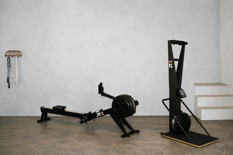 A ski machine and air rowing machine in a home gym setting.