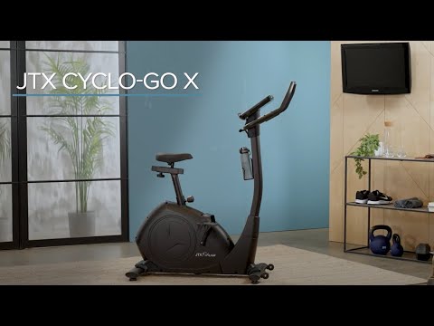 JTX Cyclo-Go X upright exercise bike in a room with blue walls and large windows.