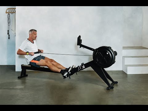 Man performing the pulling motion on a JTX Ignite AirX Rower rowing machine.