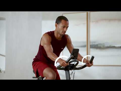 Top half of a man exercising on a JTX Cyclo-3M exercise bike.