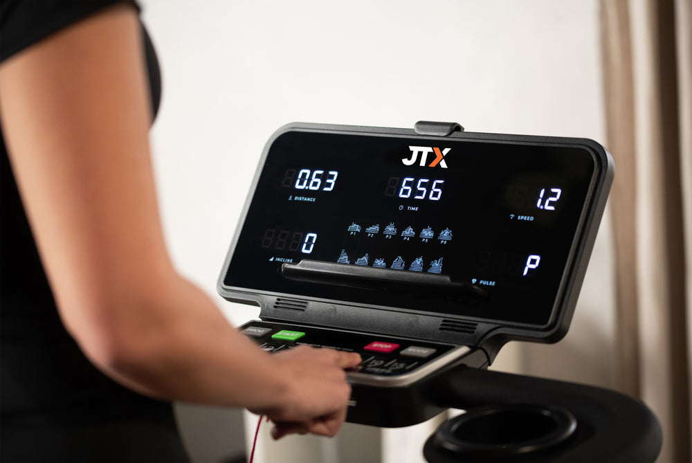 Person using the computer console of the JTX RunRise XL treadmill.