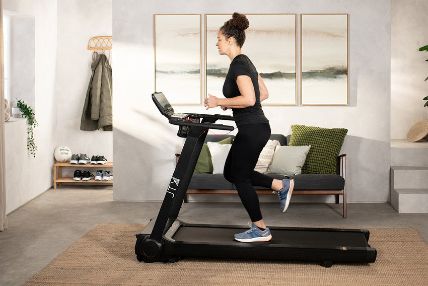 Woman running at speed on the JTX RunRise XL treadmill in their lounge.