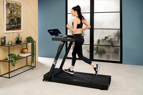 Woman running on a JTX SlimLine treadmill in a home setting.