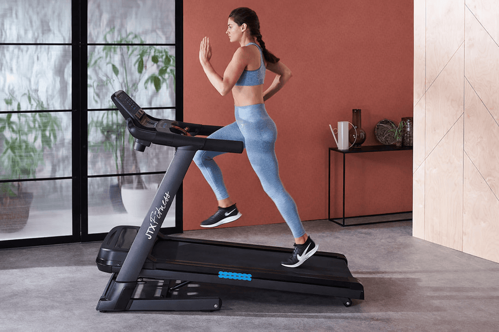Woman running at an incline on the 2023 version of the JTX Sprint-7 treadmill.