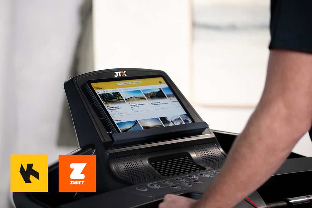 Person using Kinomap on their tablet, which is resting on the media ledge of a JTX Sprint-7 treadmill.