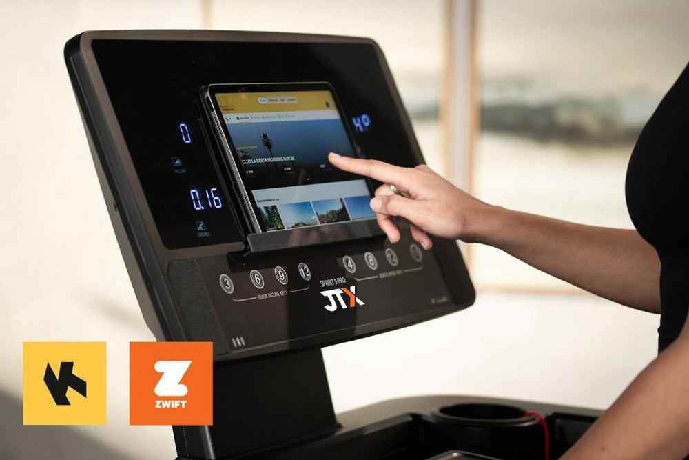 Person interacting with a treadmill console displaying a screen, with 'JTX' branding visible.