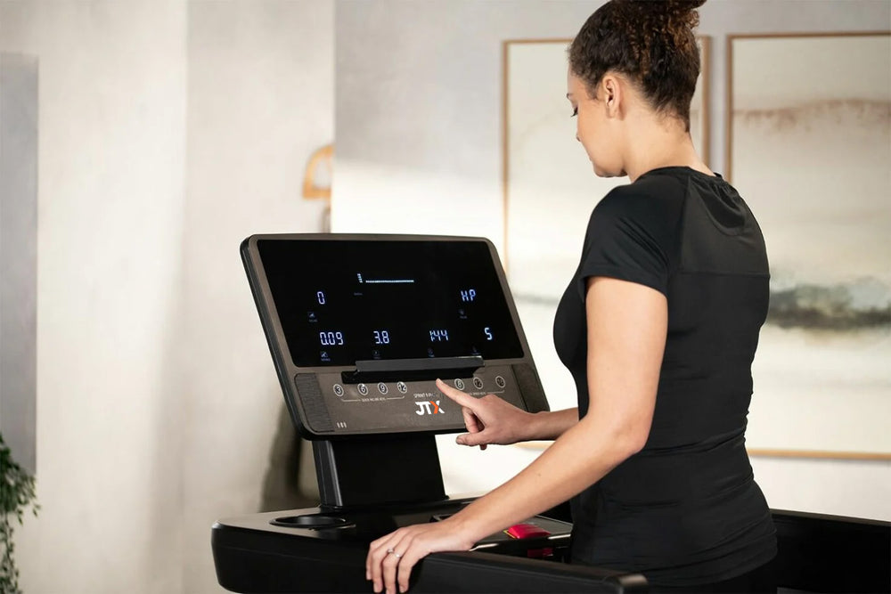 Woman using a treadmill with a digital display in a home setting