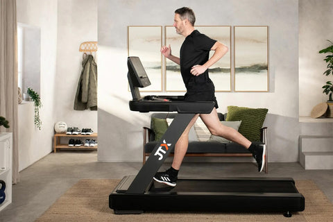 Man running on a treadmill in a modern living room.