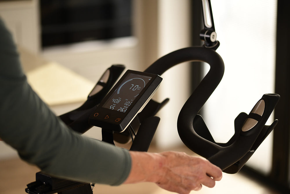 Handlebars and computer console of JTX Studio Pro exercise bike.