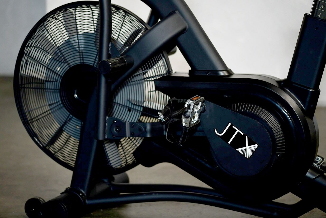 A close up image of the fan wheel, pedal and crank of the JTX Mission Air bike.
