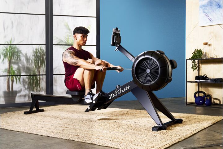 JTX Ignite Air Rowing Machine. Man rowing at home for strength and cardio fitness. 